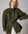 Customised vintage military khaki parka jacket with black and orange waves design across back.