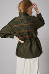Customised vintage military khaki parka jacket with black and orange waves design across back.
